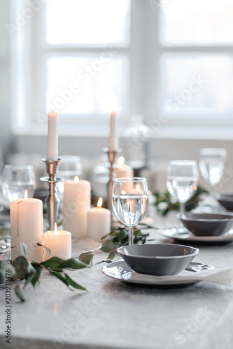 Wedding or festive table setting. Plates, wine glasses, candles and cutlery