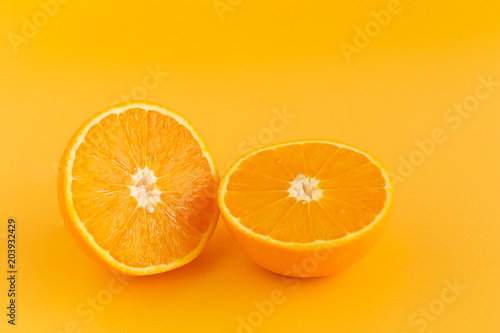 Glass of orange juice freshly squeezed on an orange background