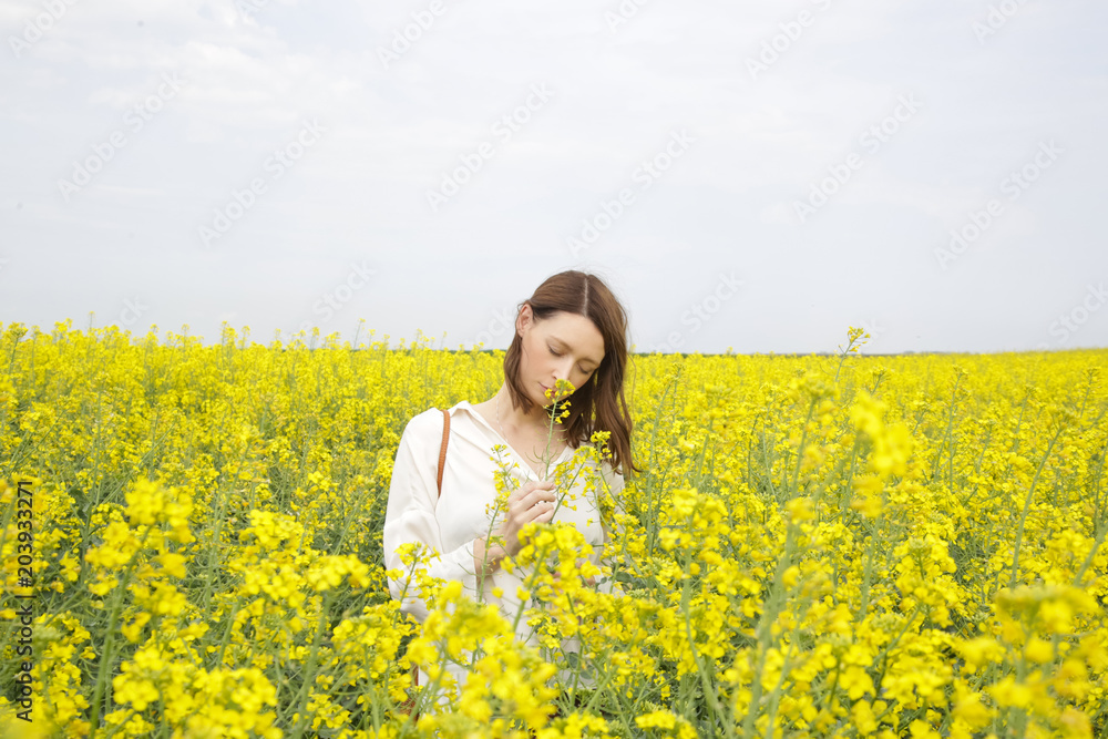 Portrait of fashionable young woman in the yellow flowers field
Portrait of fashionable young woman in the yellow flowers field