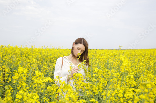 Portrait of fashionable young woman in the yellow flowers field © triocean