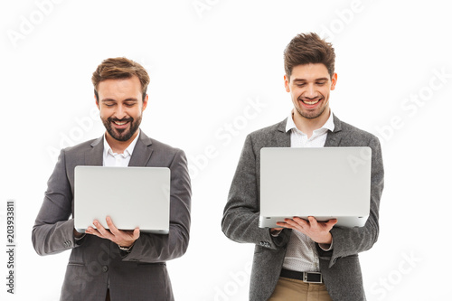 Portrait of a two excited business men using laptop