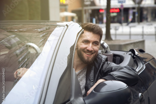 Young bearded business man is driving in luxury cabriolet car © Cara-Foto