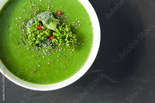 Spinach green soup with broccoli in white bowl top view