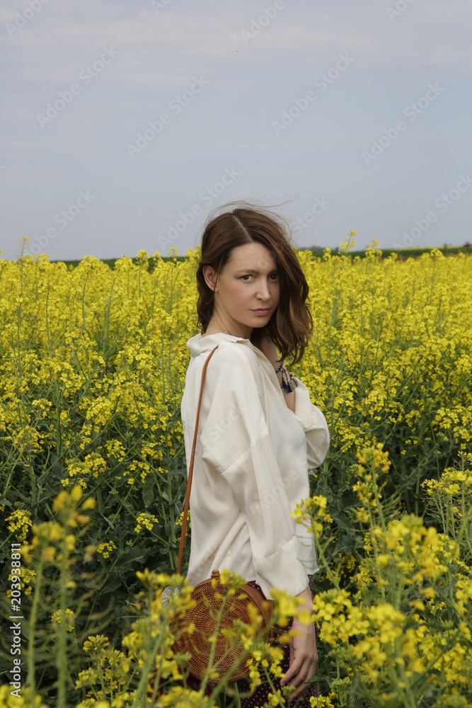 Portrait of fashionable young woman in the yellow flowers field
Portrait of fashionable young woman in the yellow flowers field