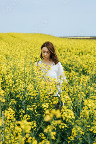 Portrait of fashionable young woman in the yellow flowers field © triocean