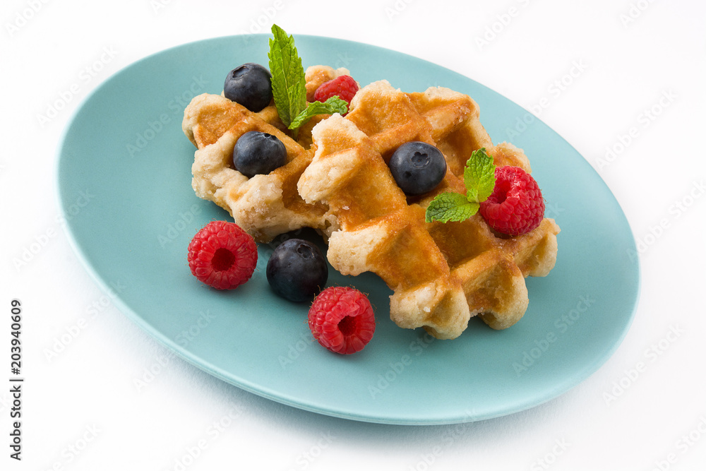 Traditional belgian waffles with blueberries and raspberries, isolated on white background.
Traditional belgian waffles with blueberries and raspberries, isolated on white background.