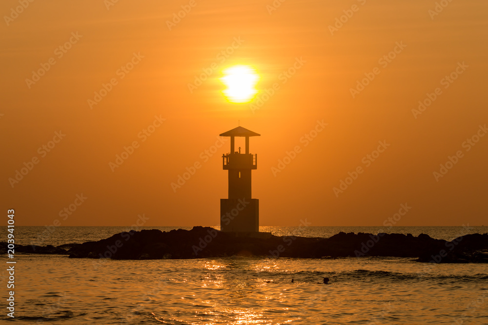 Beautiful tropical sunset behind a silhouette of a lighthouse