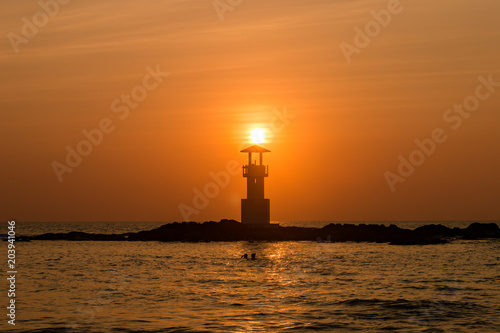 Beautiful tropical sunset behind a silhouette of a lighthouse