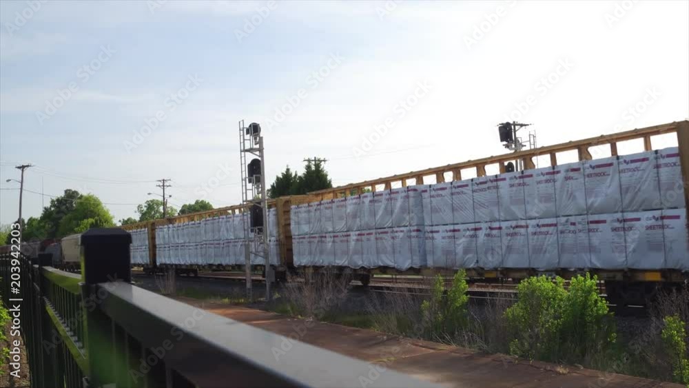Cargo Train Passing Through Town in Fence Cargo Train Passing Through Town in Fence