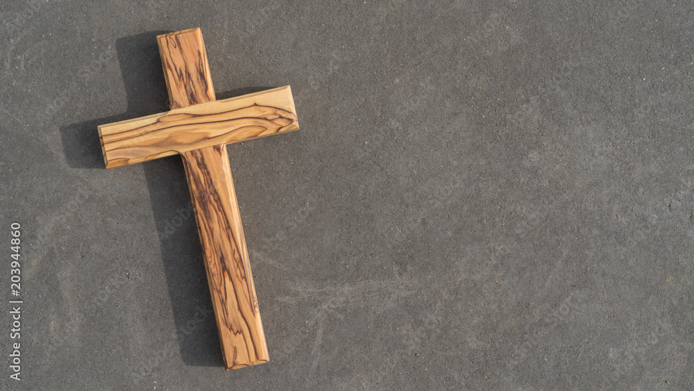 Holzkreuz liegt auf einer Steinplatte Holzkreuz liegt auf einer Steinplatte