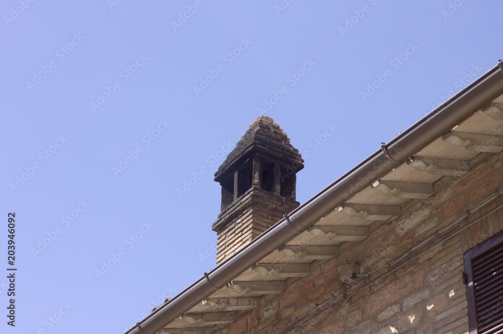 Isolated chimney on the roof - Italian architecture (Spello, Umbria, Italy)
