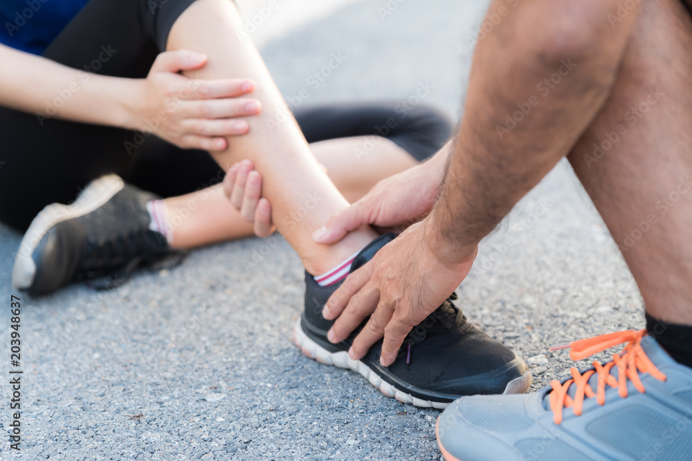 Ankle sprained. Young woman suffering from an ankle injury while ...