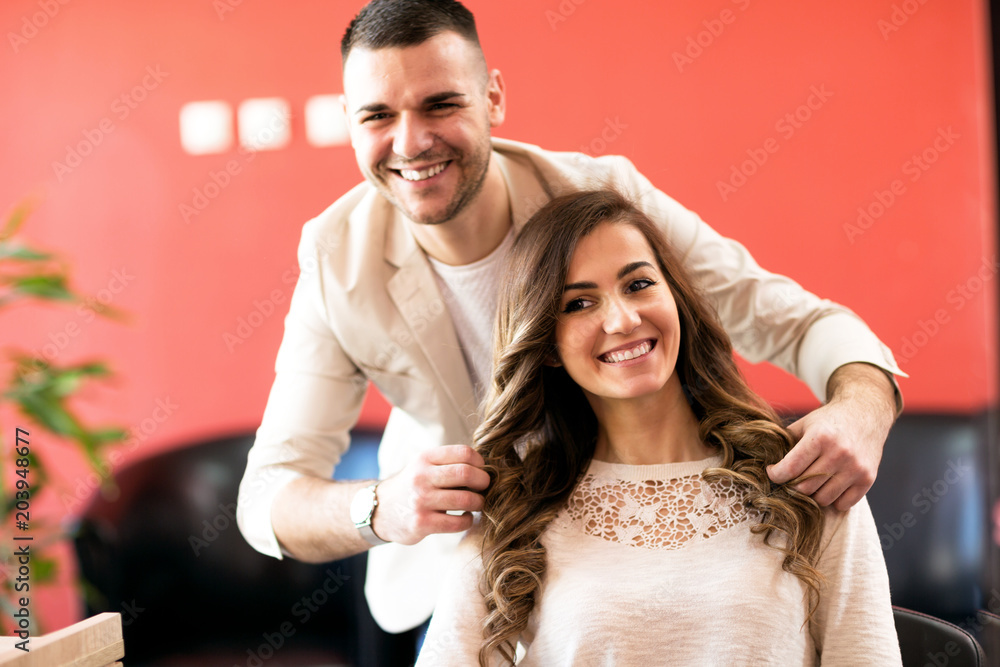 Smiling hairsyilist and his satisfied client Smiling hairsyilist and his satisfied client