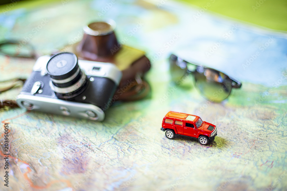 Fototapeta premium Car, glasses and camera on the world map