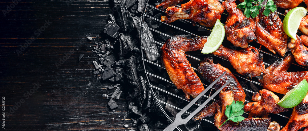 chicken wings of barbecue in honey sauce with lime slices. the dish is made and served in a rustic style chicken wings of barbecue in honey sauce with lime slices. the dish is made and served in a rustic style