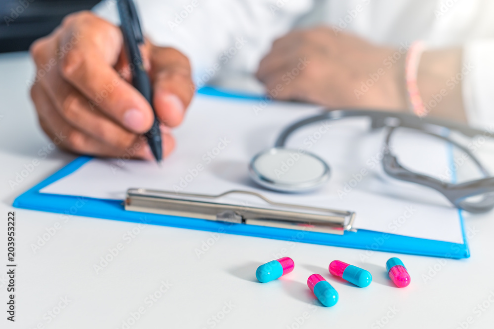 Doctor and patient are discussing about diagnosis. Medical doctor holding a stethoscope, looking at medical form and taking notes. Doctor and patient are discussing about diagnosis. Medical doctor holding a stethoscope, looking at medical form and taking notes.