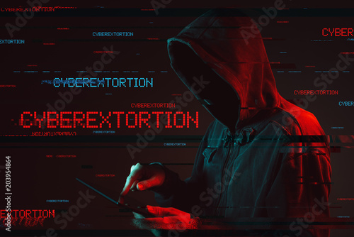 Cyberextortion concept with faceless hooded male person
