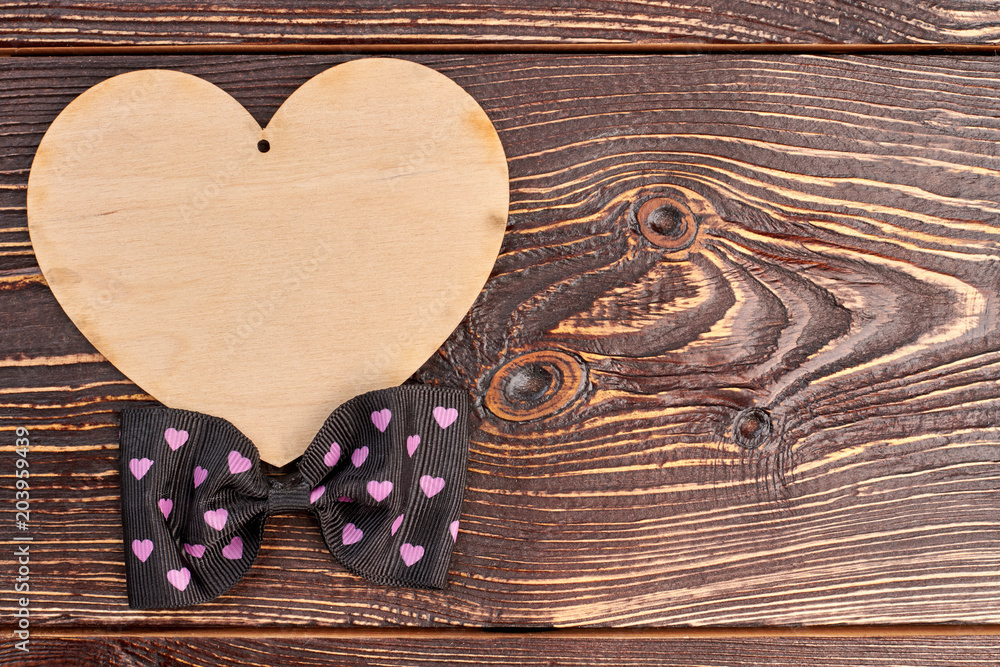 Valentines Day wooden background. Blank plywood heart and bow tie with copy space. Happy Valentines Day. Valentines Day wooden background. Blank plywood heart and bow tie with copy space. Happy Valentines Day.