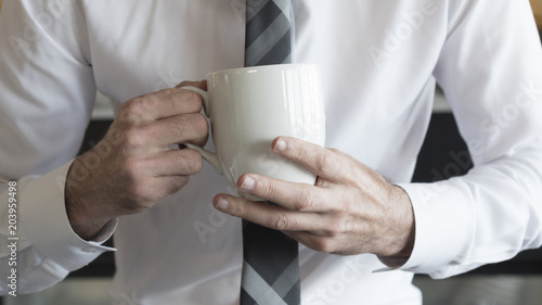 Close up coffee mug in professional businessman hands.