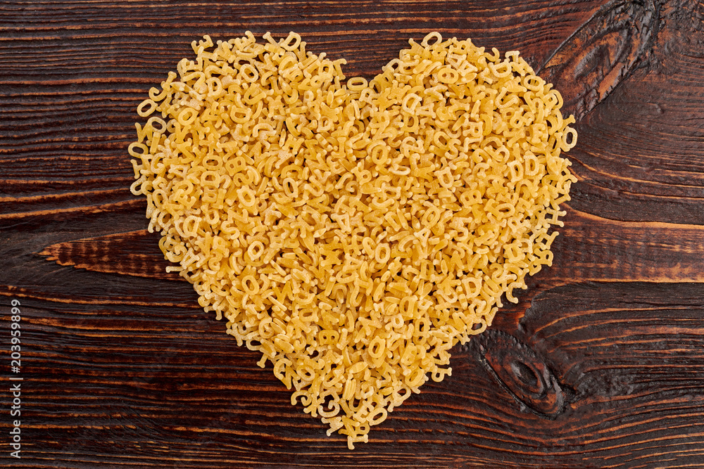 Shape of heart from italian stelline pasta. Little macaroni letters forming heart shape. Happy Valentines Day. Shape of heart from italian stelline pasta. Little macaroni letters forming heart shape. Happy Valentines Day.