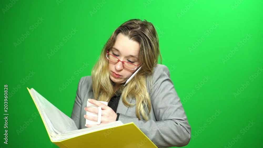 The office manager is talking on the mobile phone. Morning coffee. Looks in a folder with accounting. The office manager is talking on the mobile phone. Morning coffee. Looks in a folder with accounting.