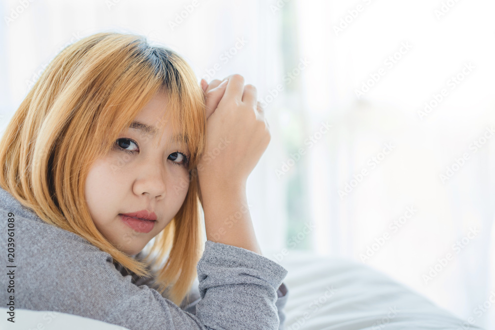 Portrait beautiful young Asian woman on bed at home in the morning. Cheerful Asian woman wearing a comfortable sweater and smiling on her bed. Relaxing room. lifestyle asia woman at home concept. Portrait beautiful young Asian woman on bed at home in the morning. Cheerful Asian woman wearing a comfortable sweater and smiling on her bed. Relaxing room. lifestyle asia woman at home concept.