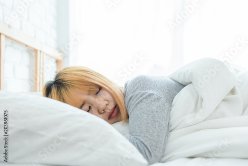 Beautiful young Asian woman sleeping in bed in the morning. Attractive asian girl use bedtime in her comfortable bedroom. Relaxation bedroom. Iifestyle asia woman at home concept.