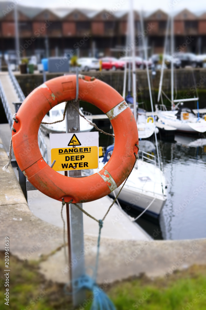 Water safety life deep risk danger red orange buoy ring save swimmer dock harbour harbor coastal sea marina