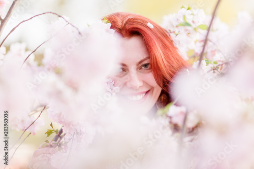 beautiful woman between almond blossoms