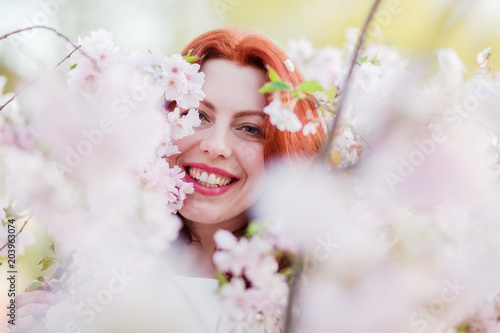 beautiful woman between almond blossoms