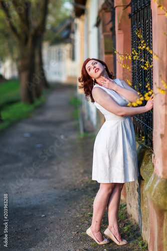 beautiful woman poses at a fence