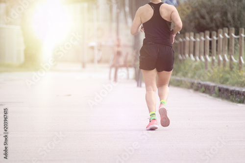 Woman running in the park against the sun light. Empty copy space for Editor's text.