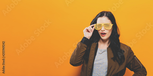 Fashionable woman in a bomber jacket on a golden yellow background