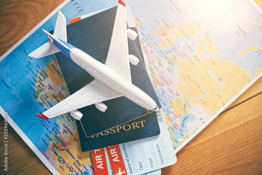 Naklejka premium Model samolotu z mapą świata, paszportami i biletami jako podróż samolotem i koncepcja rezerwacji biletów