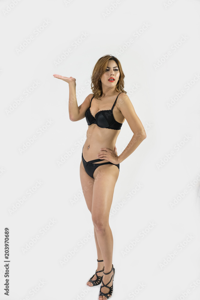 Woman in sexy  swimsuit poses in bedroom.