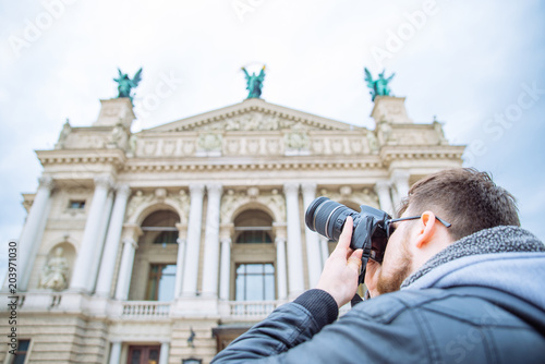 tourist man taking picture of old european architecture. copy space. travel concept