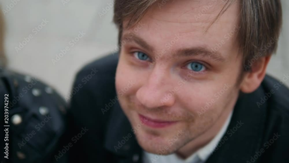 Outdoor portrait of modern young man with mobile phone in the street looking on camera Outdoor portrait of modern young man with mobile phone in the street looking on camera
