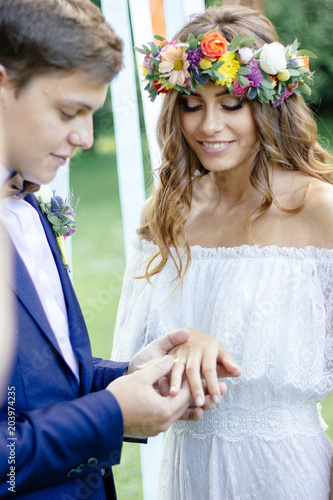 Groom put on a ring to brid...