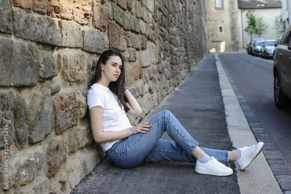 Young beautiful dark-haired girl model appearance in an old town in the spring. Young beautiful dark-haired girl model appearance in an old town in the spring.
