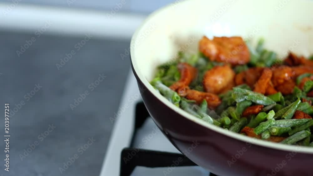 Chef stirring green beans with chicken meat and soy sauce in wok. Chinese food preparation at home Chef stirring green beans with chicken meat and soy sauce in wok. Chinese food preparation at home