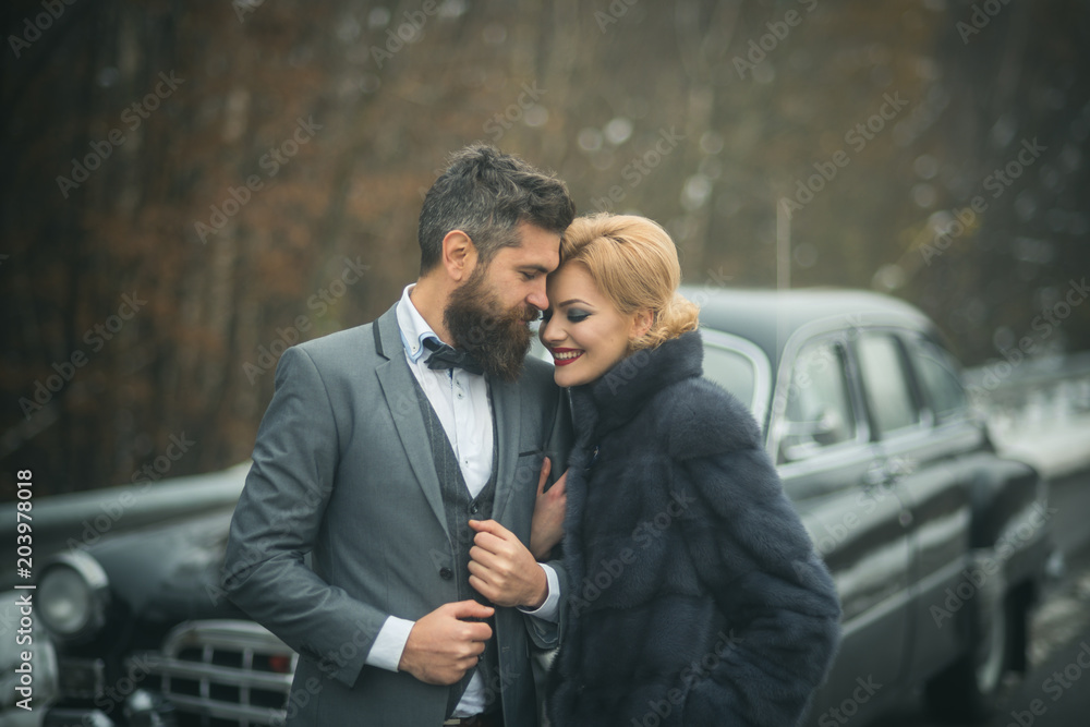 Young beautiful couple relaxing together walking at a retro car. Young beautiful couple relaxing together walking at a retro car.