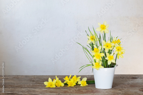 Fototapeta Naklejka Na Ścianę i Meble -  yellow narcissus in vase on old wooden wall