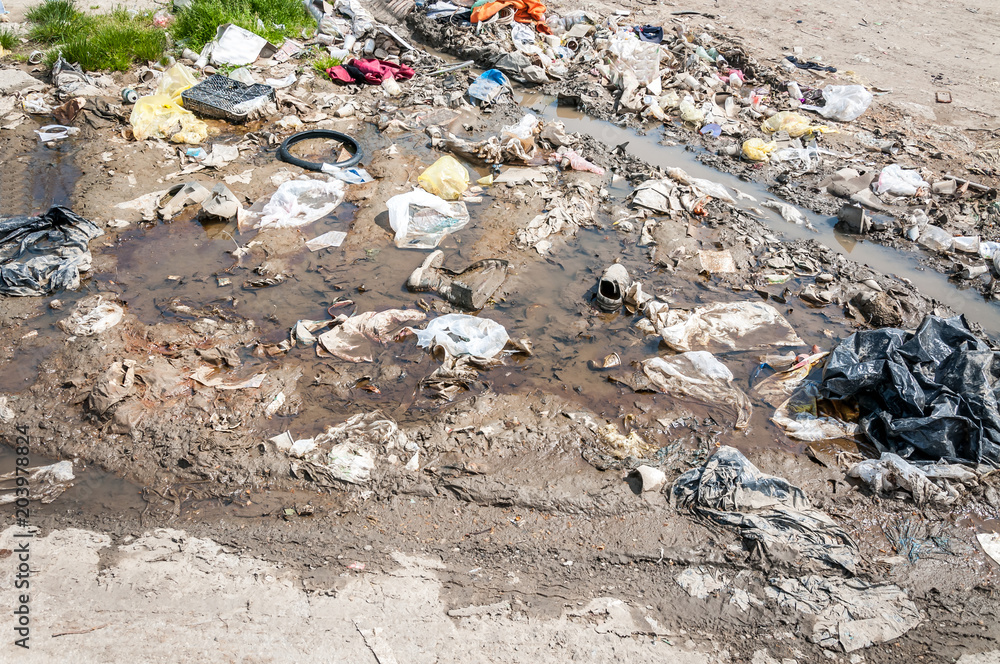 Big pile of garbage and junk in the river water polluting the nature with litter