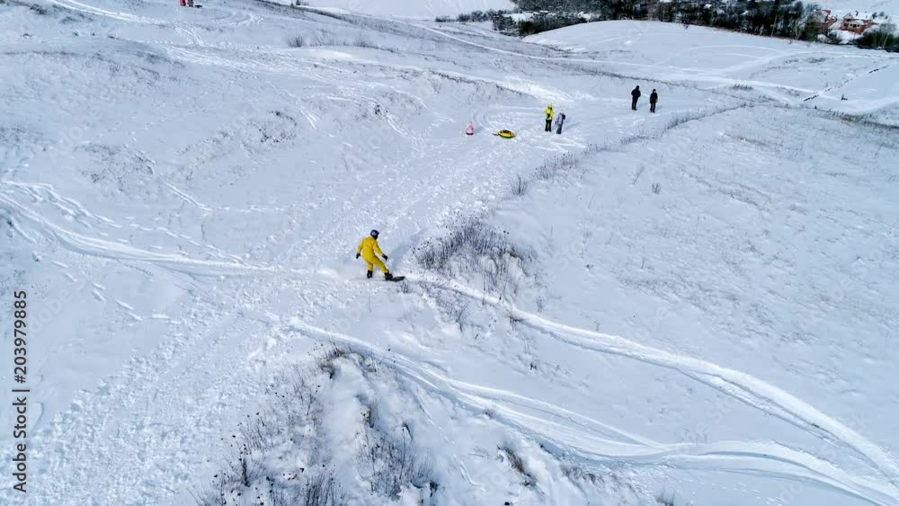 Snowboarder riding down the slope on a snowy field, 4k video clip. Aerial shot of snowboarding Snowboarder riding down the slope on a snowy field, 4k video clip. Aerial shot of snowboarding
