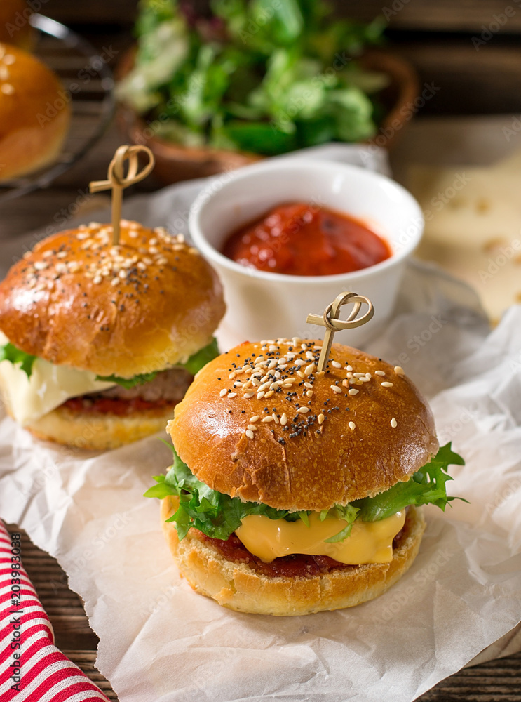 Mini cheeseburgers sliders with ground beef, cheddar, lettuce and tomato sauce