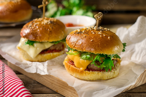 Mini cheeseburgers sliders with ground beef, cheddar, lettuce and tomato sauce