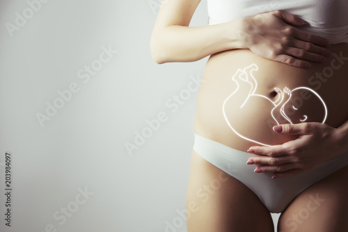 pregnant woman closeup of belly with visualisation of baby inside Fototapet