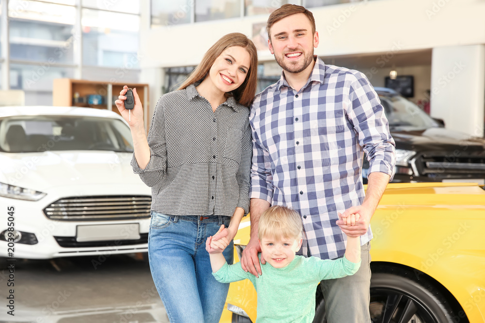 Young family holding car key in salon Young family holding car key in salon