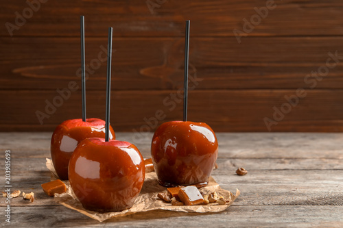 Delicious red caramel apples on table