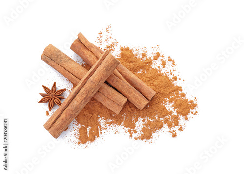 Fotografia Aromatic cinnamon sticks and powder on white background